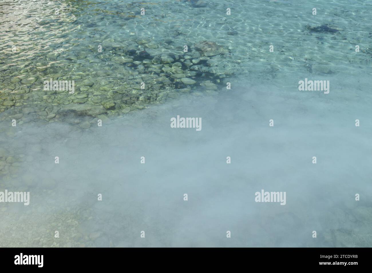 Substance blanche trouble dans de l'eau claire et peu profonde Banque D'Images