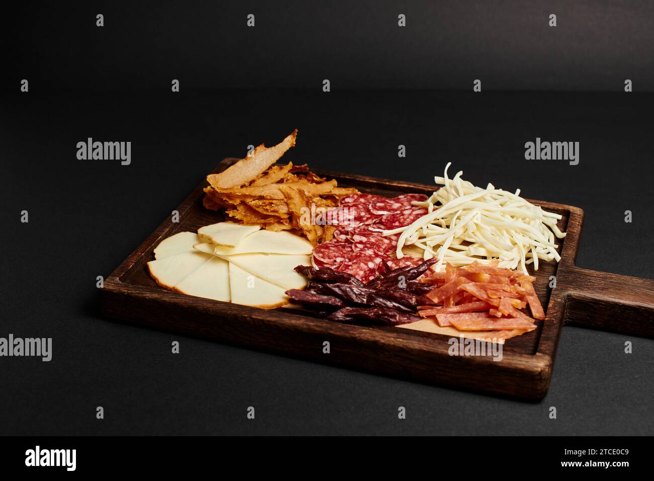 planche de charcuterie avec sélection de fromages, bœuf séché et tranches de salami sur planche à découper en bois Banque D'Images