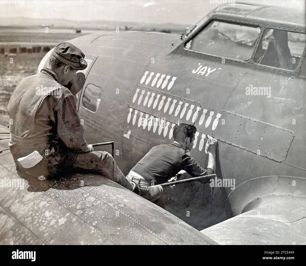Un membre d'équipage d'un B-17 Bomb Group de l'USAAF basé en Afrique du Nord à l'été 1943 enregistre les 32 missions de bombardement réussies de son avion et un navire coulant sous le cockpit qui porte le nom chrétien Jay du pilote. Ailleurs sur le nez de l'avion est peint son surnom la Goon. Photo : Robert CAPA Banque D'Images