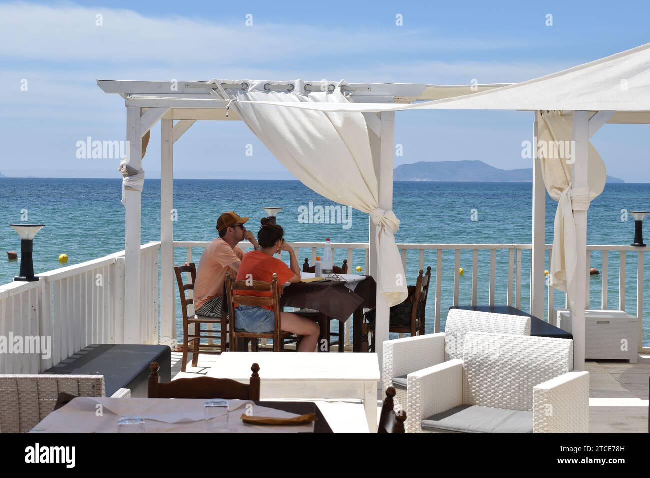 Jeune couple assis à une table avec vue sur la mer Méditerranée dans le restaurant sicilien Lido Playa de Rio dans le village de San Teodoro Banque D'Images