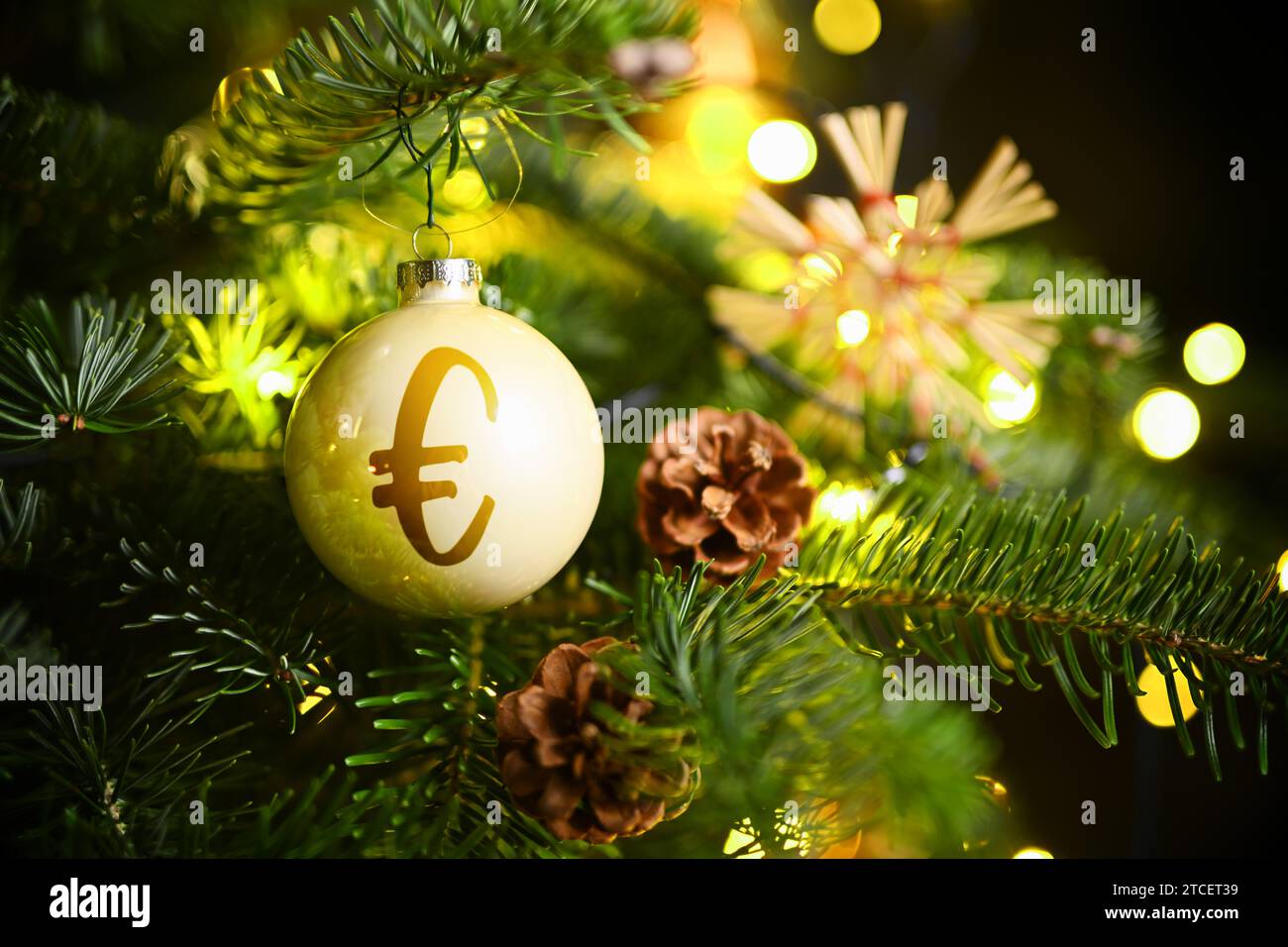 Boule de Noël avec Eurosign accroche sur Un arbre de Noël, symbole photo argent de Noël, photo montage Banque D'Images