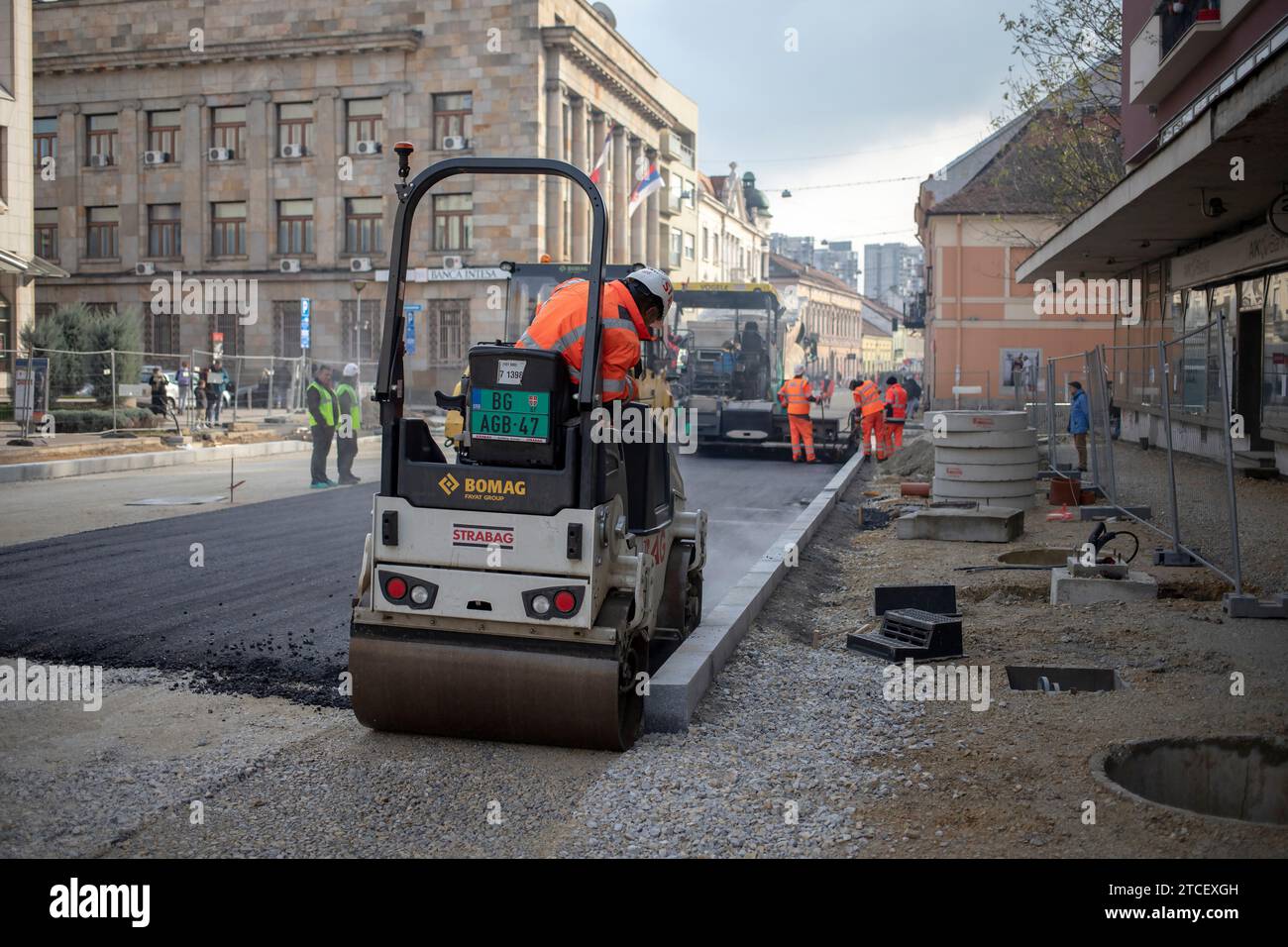 Belgrade, Serbie, le 9 décembre 2023 : rouleau à double tambour et machine à asphalte posant de nouveaux asphaltes le long de la rue en cours de reconstruction Banque D'Images