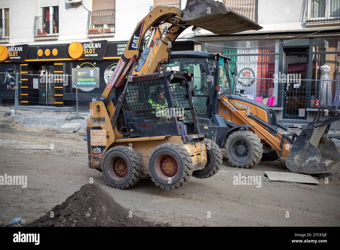 Belgrade, Serbie, le 9 décembre 2023 : une chargeuse sur pneus accélère sur les roues arrière dans la rue en cours de reconstruction Banque D'Images