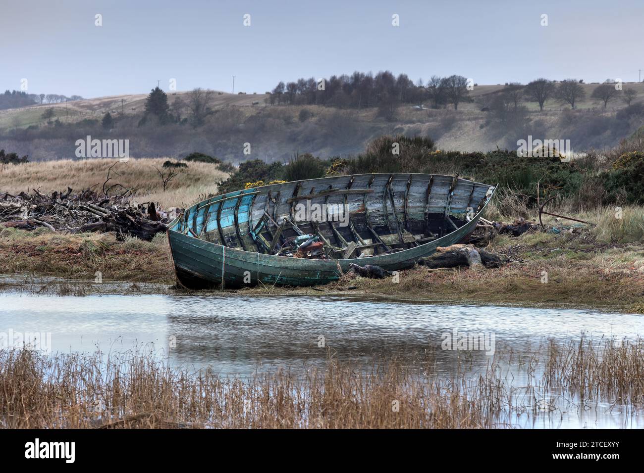 Un bateau de pêche abandonné en bois sur les dunes de sable dans l'estuaire de la rivière Esk, St Cyrus, Aberdeenshire, Écosse Banque D'Images