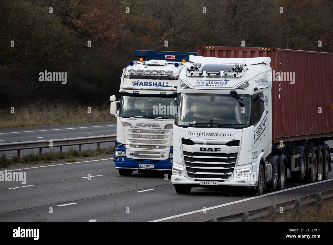 Camions Scania et DAF côte à côte sur l'autoroute M40, Warwickshire, Royaume-Uni Banque D'Images