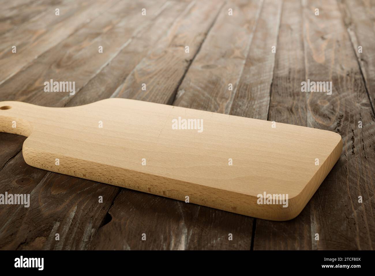 Planche à découper rectangulaire en bois sur table rustique. Banque D'Images