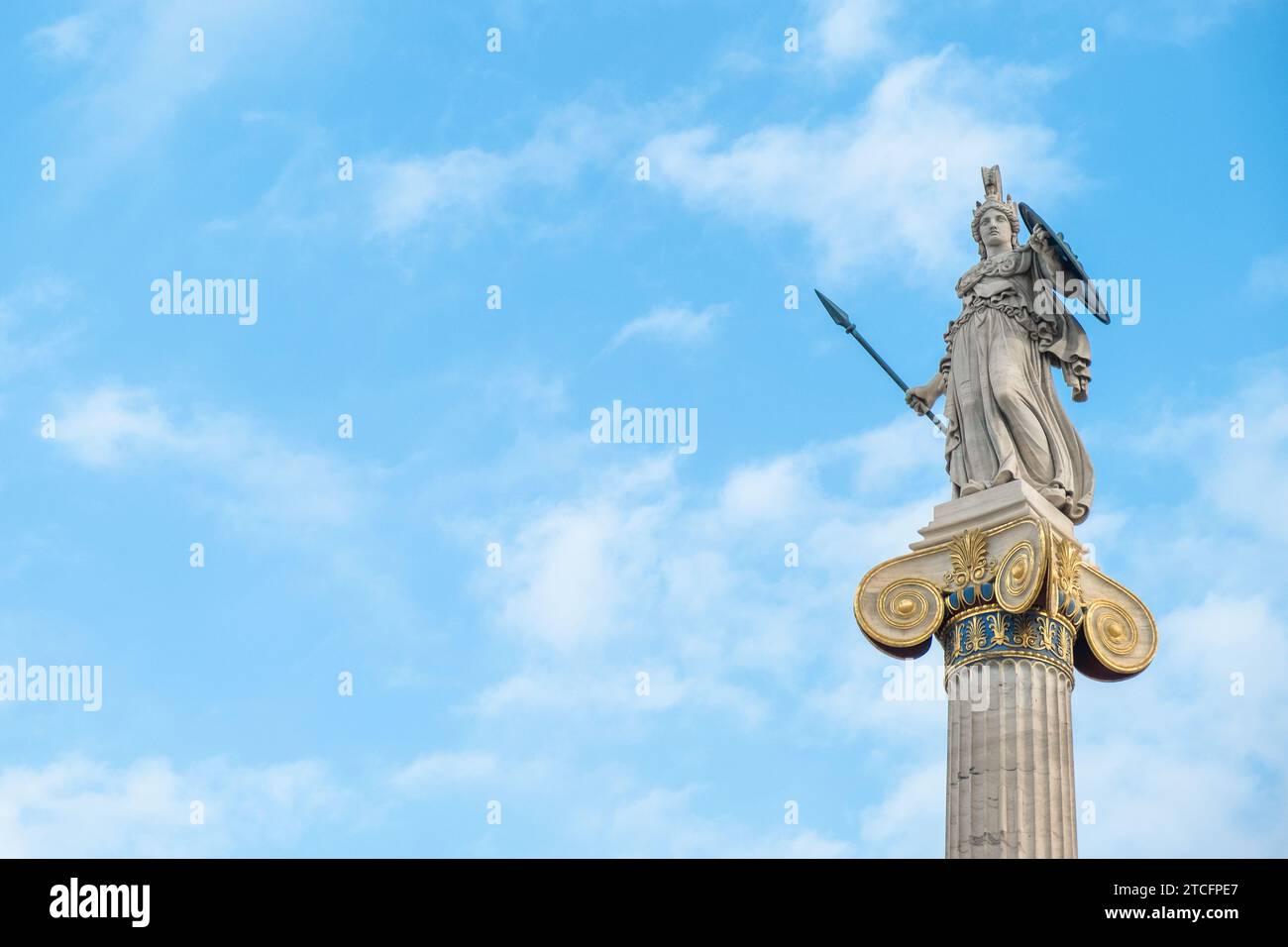 Athènes, Grèce - 4 décembre 2023 : statue d'Athéna sur colonne de marbre de l'Académie d'Athènes, Grèce contre ciel bleu. Site d'intérêt populaire et voyage Banque D'Images