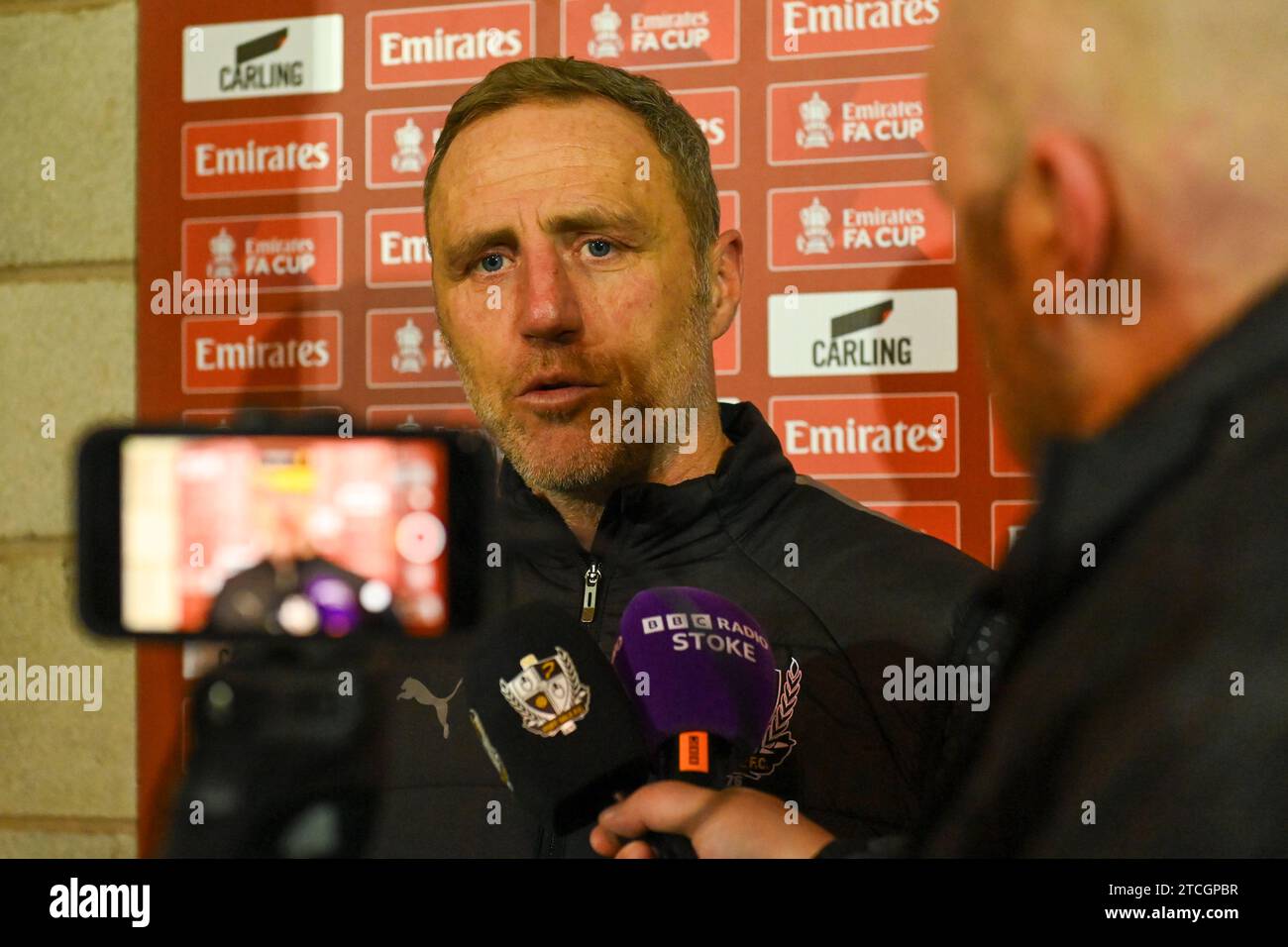 Burslem, Royaume-Uni, 12 décembre 2023. Andy Crosby, Manager de Port Vale, donne son interview d'après-match après la défaite de penalty du 2e tour de la FA Cup contre Stevenage Borough. Crédit : TeeGeePix/Alamy Live News Banque D'Images