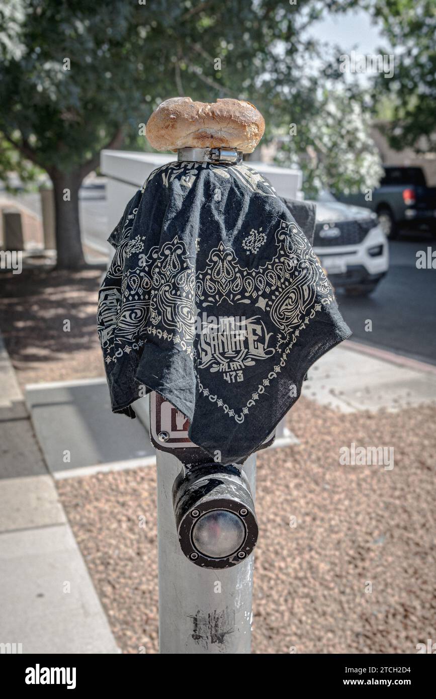 Un bandana bleu et bagel au sommet du poteau de bouton-poussoir avec bouton de passerelle, à gauche pour les sans-abri sur Central Avenue à Nob Hill, Albuquerque, Nouveau Mexique, USA. Banque D'Images