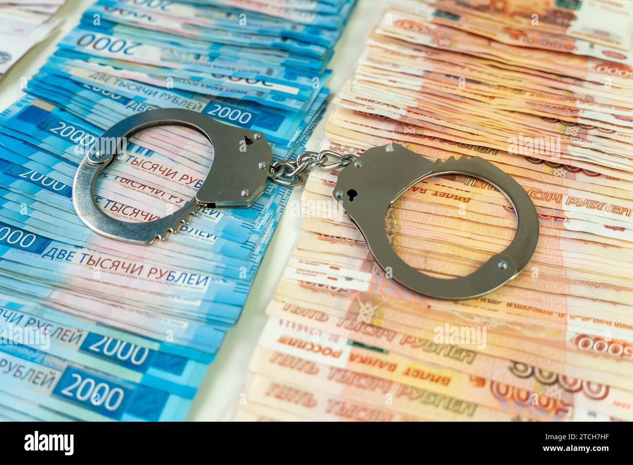 menottes en métal sur fond de rouble russe en monnaie liquide. Le concept de corruption ou d'argent criminel. Banque D'Images