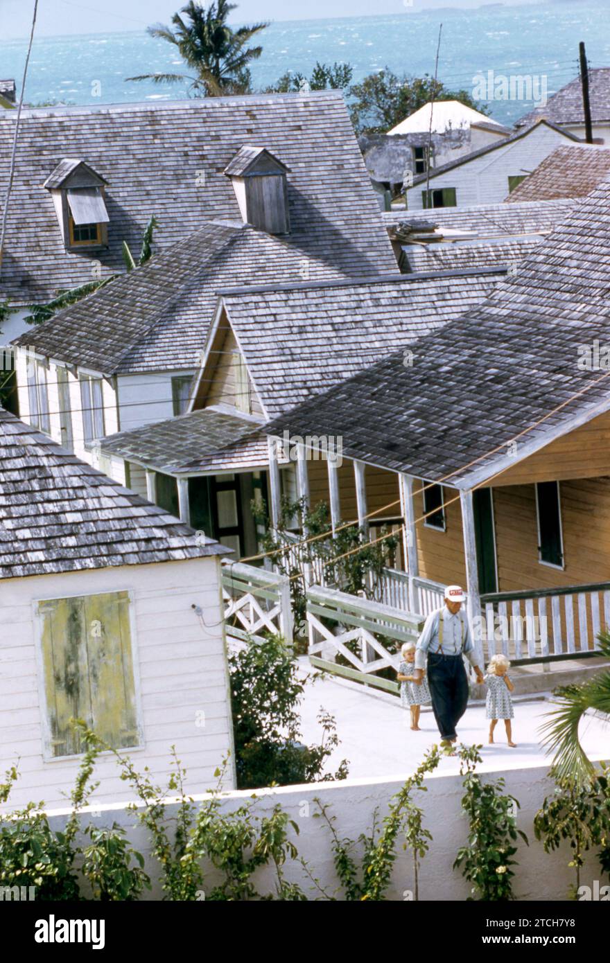 GREEN TURTLE CAY, ABACO, BAHAMAS - AVRIL 28 : un homme aîné marche sur un chemin avec ses petits-enfants près de leur maison le 28 avril 1956 à Green Turtle Cay, Abaco, Bahamas. (Photo de Hy Peskin) Banque D'Images