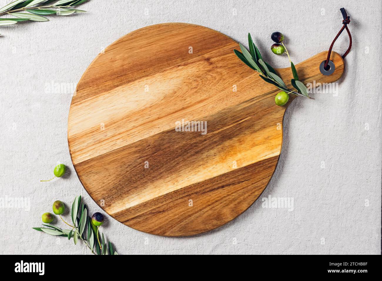 Cercle en bois de coupe ou de service, olives et branches d'olivier, modèle pour l'affichage du produit Banque D'Images