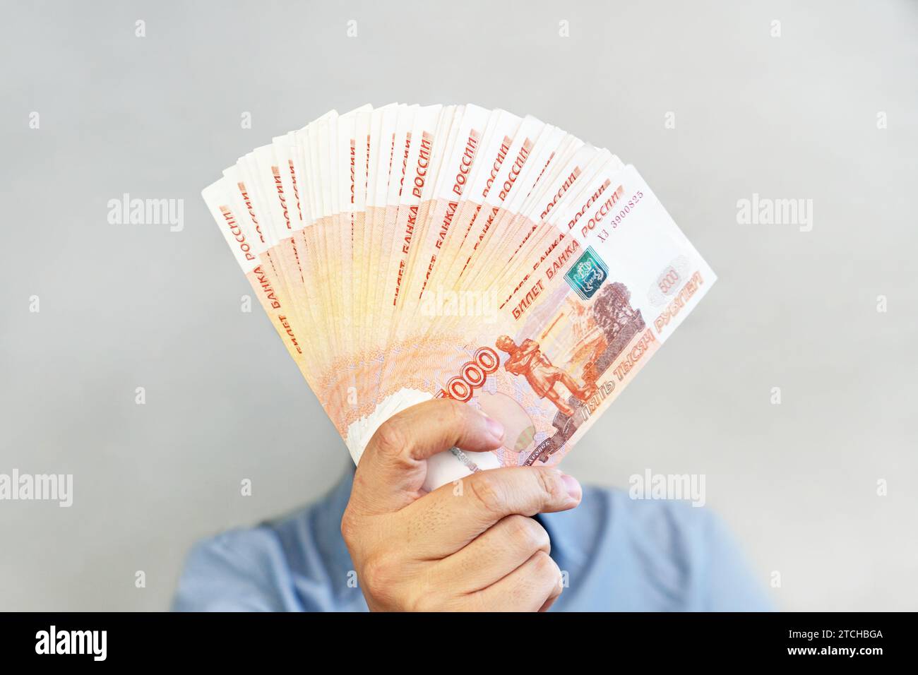 millions de roubles en main. Les mains des hommes en gros plan tiennent une liasse d'argent russe de cinq mille billets. Banque D'Images
