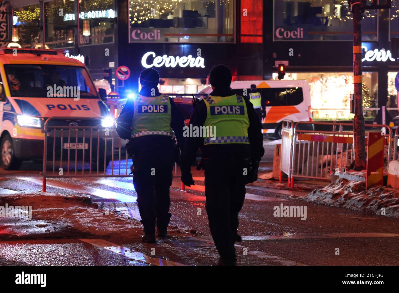 Les policiers en uniforme complet marchent ensemble devant une voiture de police à Stockholm, en Suède Banque D'Images