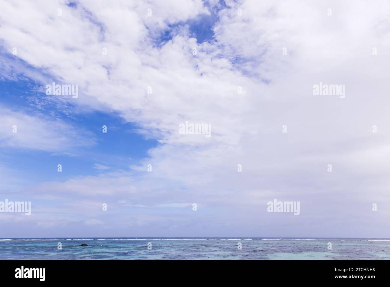 L'eau de l'océan est sous le ciel bleu avec des nuages blancs. Vue sur la plage de l'île de la Digue, Seychelles Banque D'Images