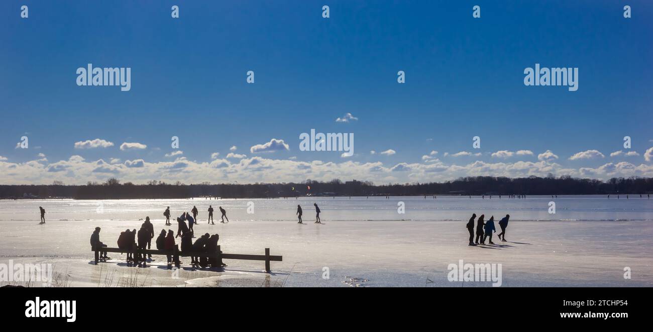 Silhouettes de patineurs sur le lac Paterswoldse Meer à Groningen, pays-Bas Banque D'Images