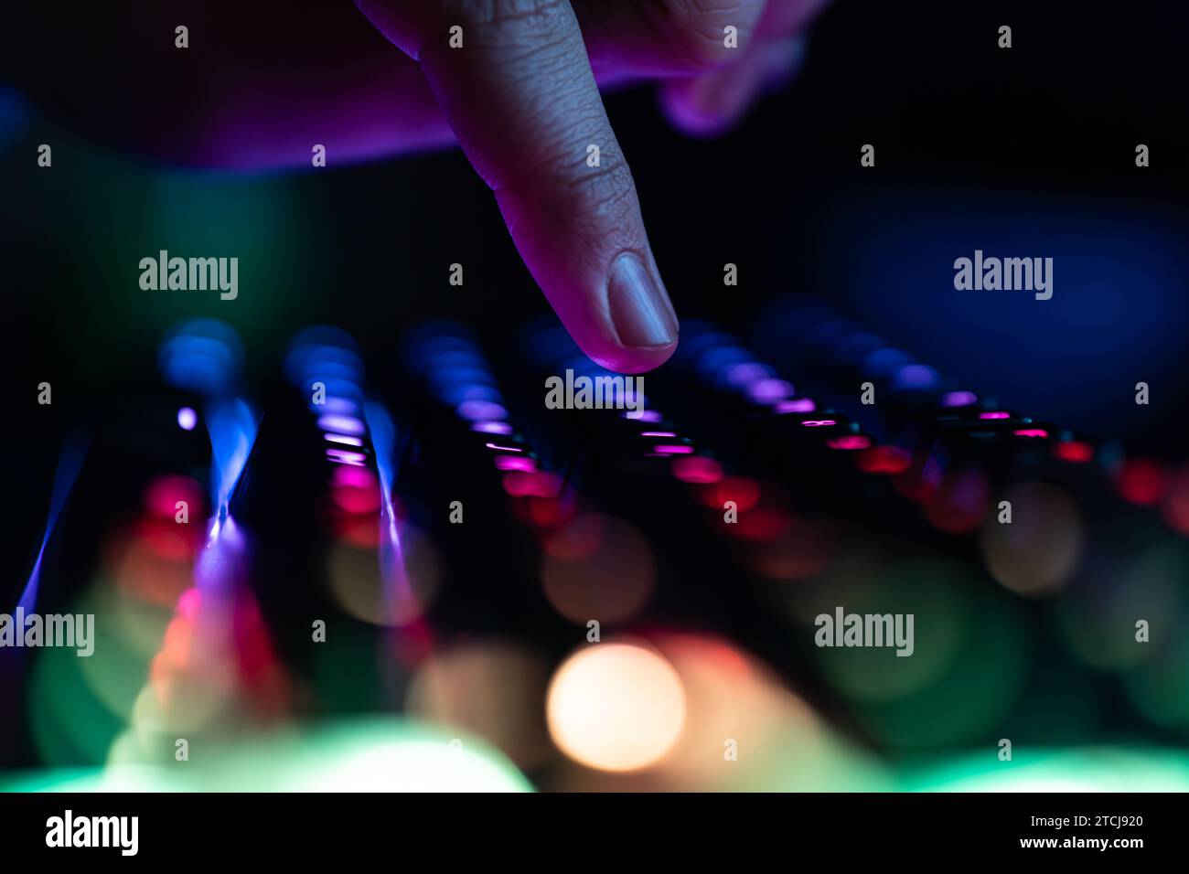 Jeux vidéo informatiques, piratage, technologie, concept Internet. Foyer sélectionné. Clavier d'ordinateur au néon avec rétroéclairage couleur. Un doigt rapproché appuie dessus Banque D'Images