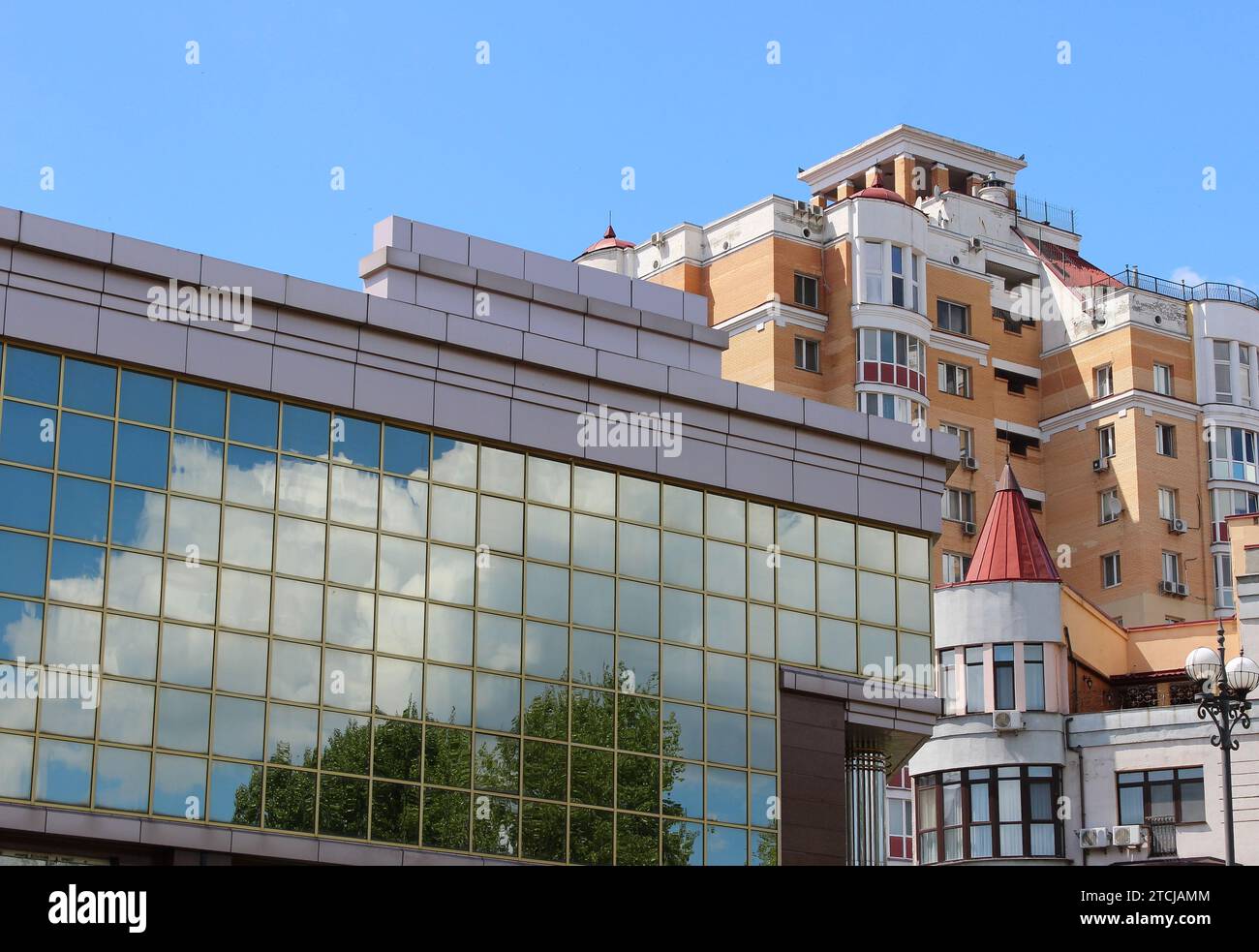 Façade miroir de l'immeuble de bureaux avec reflet des arbres et des nuages en face de Variety Apartment Houses Banque D'Images