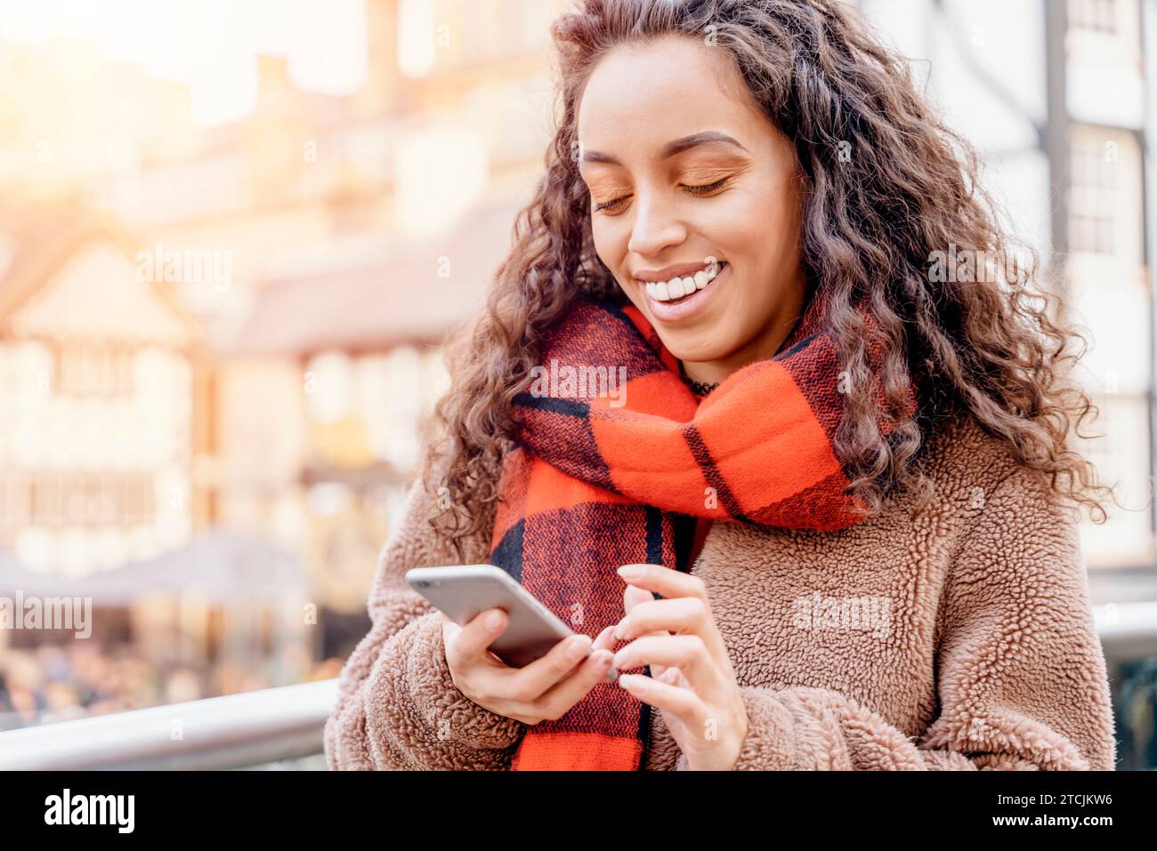 Portrait en plein air d'une femme heureuse parlant au téléphone dans une ville en Angleterre Banque D'Images