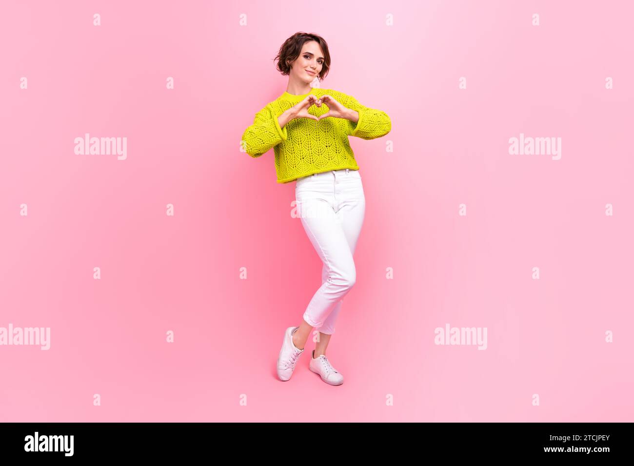 Photo pleine longueur de funky positive Lady Wear pull-over en tricot montrant les bras coeur isolé fond de couleur rose Banque D'Images