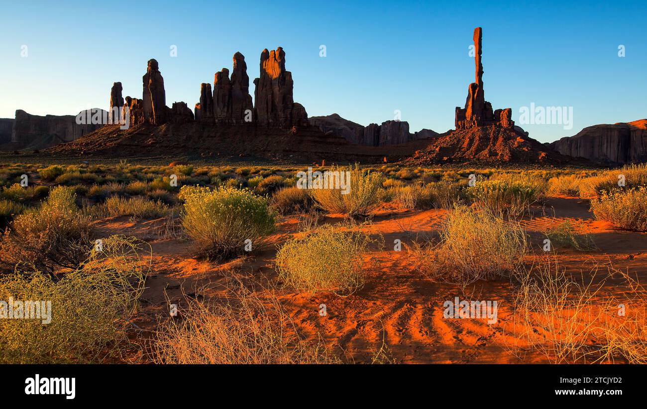 Belle vue sur les formations de grès étonnantes dans le célèbre lever du soleil au pôle Totem et dunes de sable, Monument Valley, Arizona, États-Unis Banque D'Images