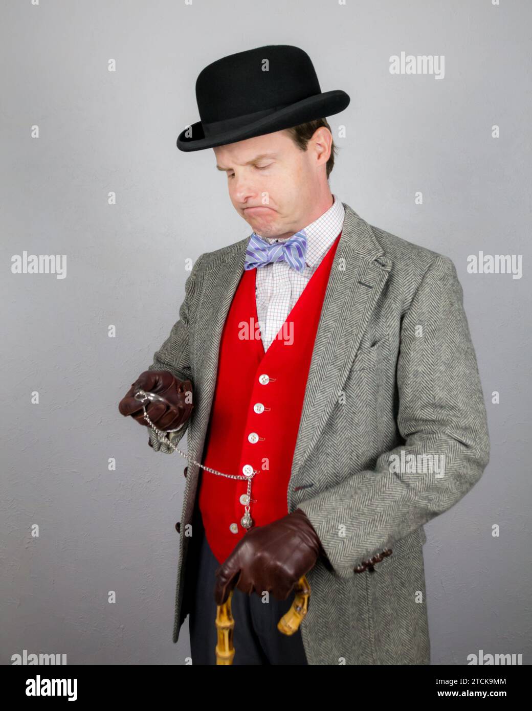 Portrait de Vintage British Gentleman en veste Tweed et gilet rouge tenant la montre de poche. Style vintage et mode rétro. Banque D'Images