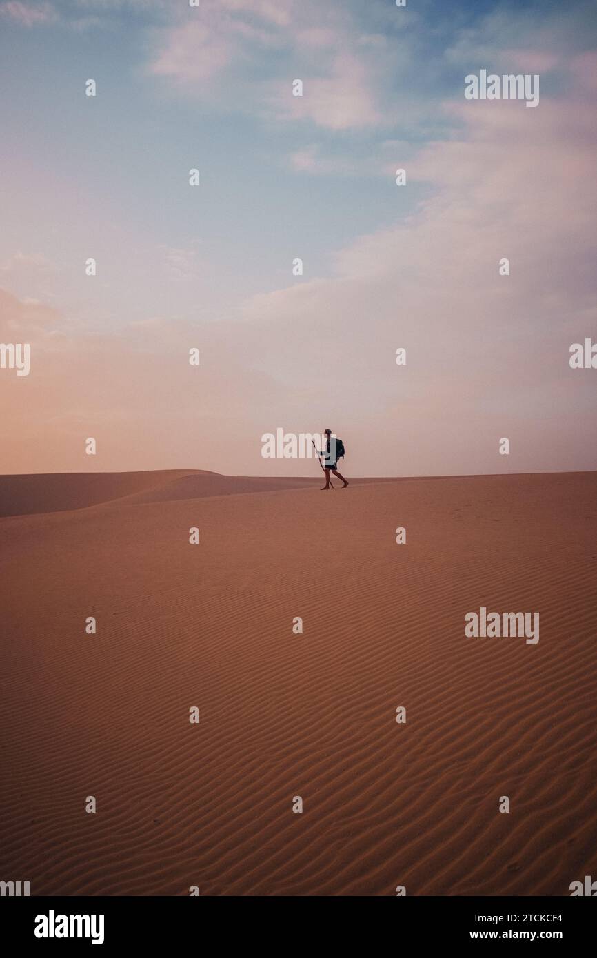 Un voyageur solitaire marchant à travers un désert Banque D'Images