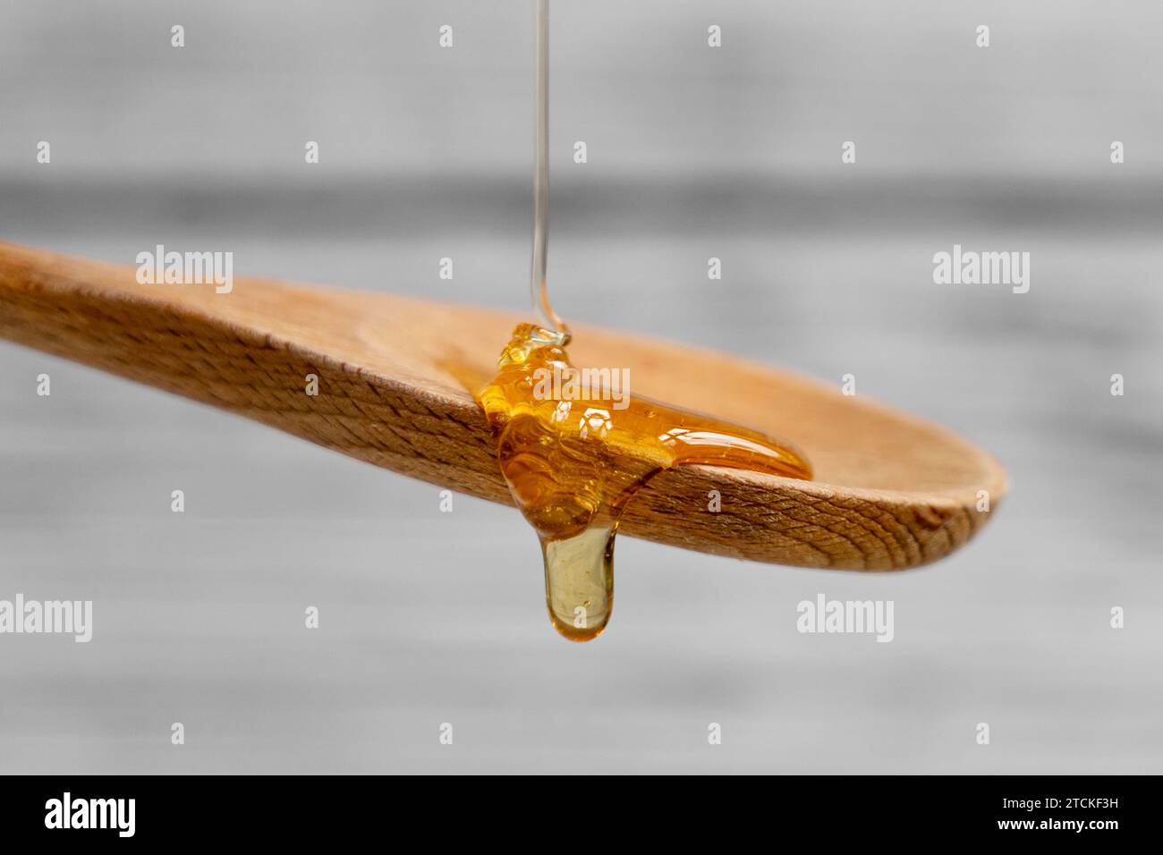 Verser du miel sur une cuillère en bois, illustration de nourriture Banque D'Images