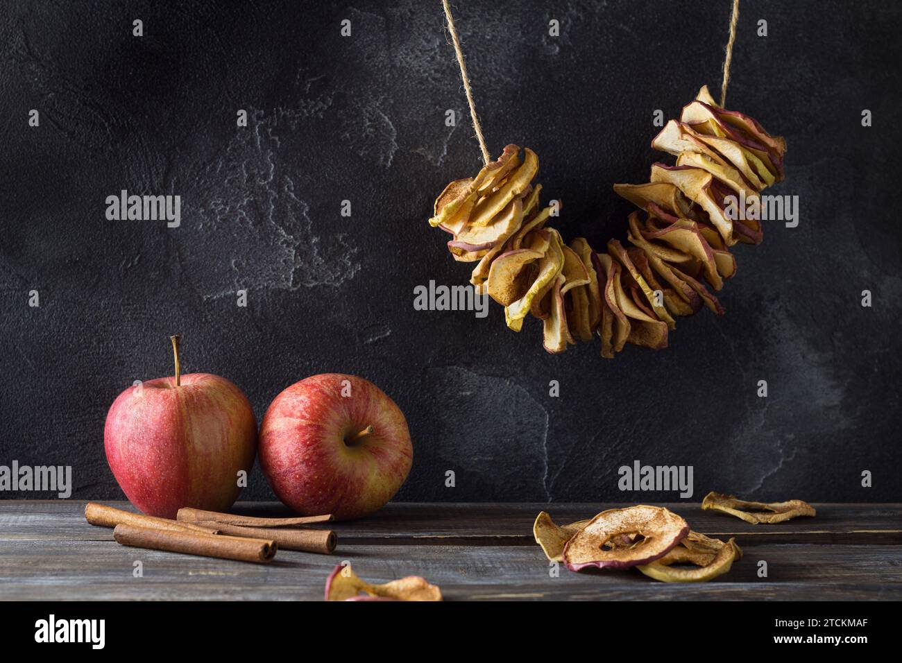 Pommes séchées maison à la cannelle, chips de pomme sur fond en bois. Délicieux en-cas sain Banque D'Images