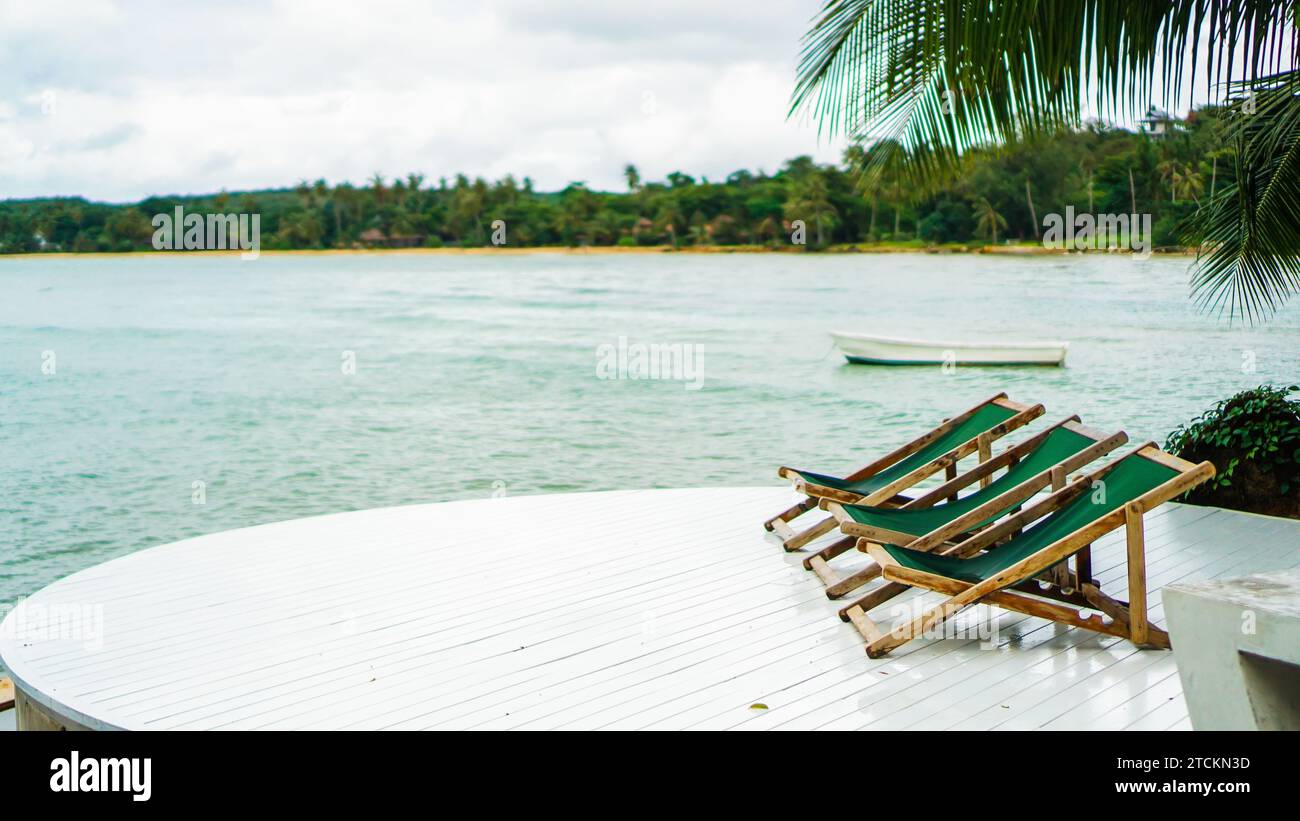 Beau paysage tropical, deux chaises longues ou chaise de plage, chaises longues, parasol sous le palmier. Sable blanc, vue sur la mer avec horizon, calme et relaxatio Banque D'Images