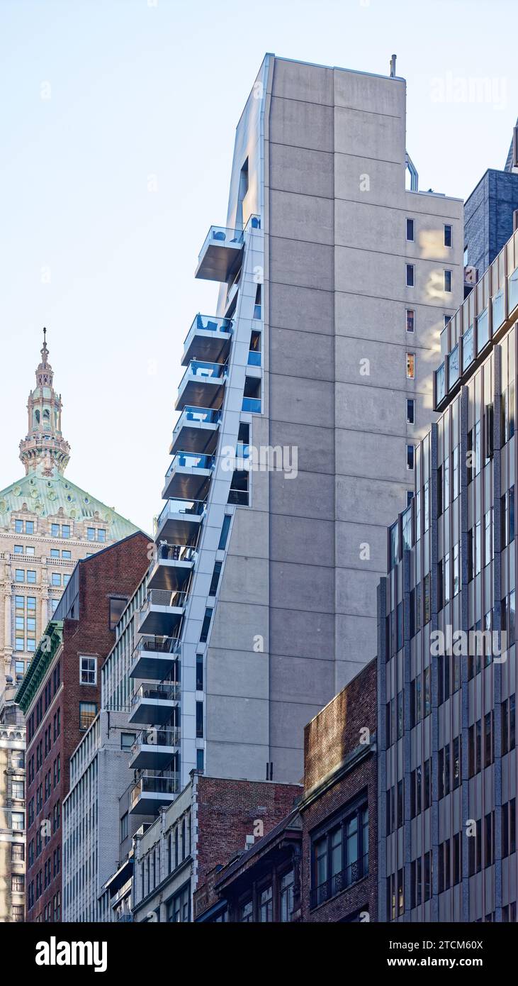 La forme grise en forme de coin du Gotham Hotel semble inspirée du Forum culturel autrichien six pâtés de maisons au nord de Midtown Manhattan. Banque D'Images