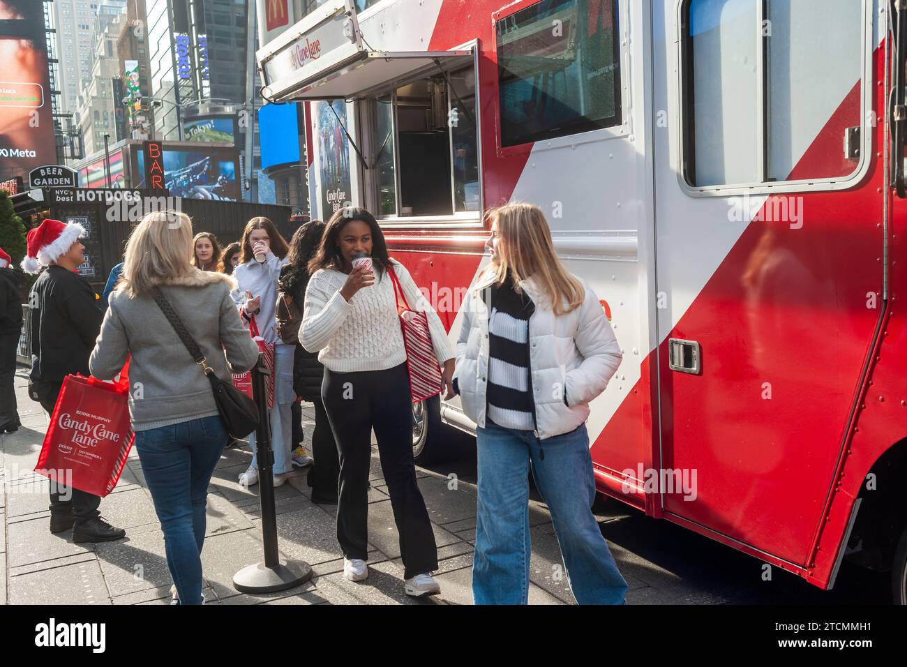 Les gens attendent sur la ligne pour un chocolat chaud gratuit à une activation de marque du film « Candy Cane Lane » d’Amazon Prime Videos avec Eddie Murphy, à Times Square à New York le samedi 2 décembre 2023. (© Richard B. Levine) Banque D'Images