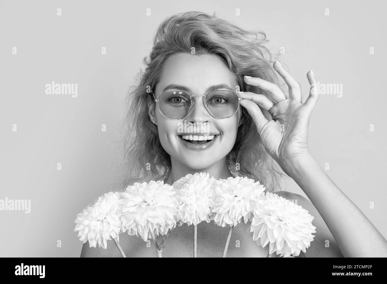 photo de fille positive avec des fleurs de chrysanthème de jour de femmes. fille avec des fleurs de jour de femmes isolé sur jaune. fille avec des fleurs de jour de femmes dans le studio. Banque D'Images