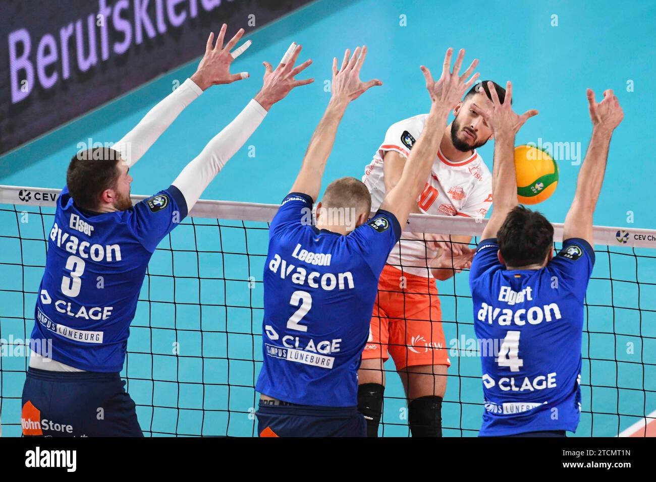 13.12.2023, LKH Arena, Lueneburg, GER ; CEV Champions League, SVG Lueneburg vs Jastrzebski Wegiel, im Bild Jesse Elser (Lueneburg #03), Blake Leeson (Lueneburg #02) und Maxwell Elgert (Lueneburg #04) versuchen sich gegen Ryan Sclater (Wegiel #10) durchzusetzen Foto ? Nordphoto GmbH/ Witke Banque D'Images