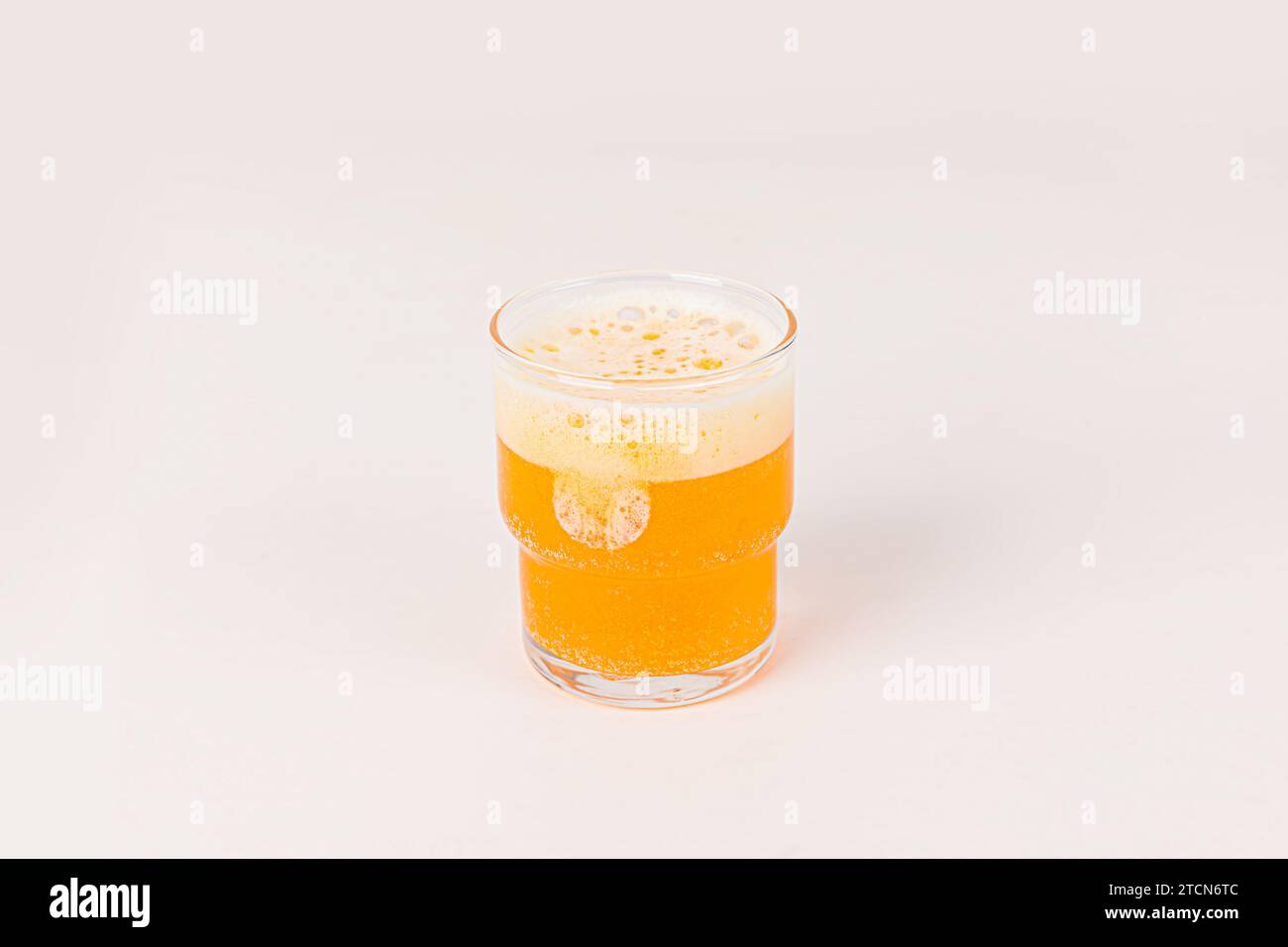 Comprimé effervescent orange de vitamine C a chuté et se dissoudre dans un verre d'eau avec des bulles isolées sur fond blanc Banque D'Images