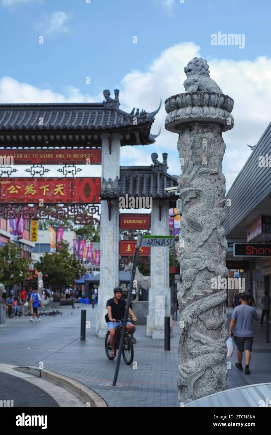 Une colonne de dragon en pierre sculptée surmontée d'un lion devant les portes cérémonielles chinoises Cabramatta, Pai Lau, sur le centre commercial Cabaramatta, Western Sydney Banque D'Images