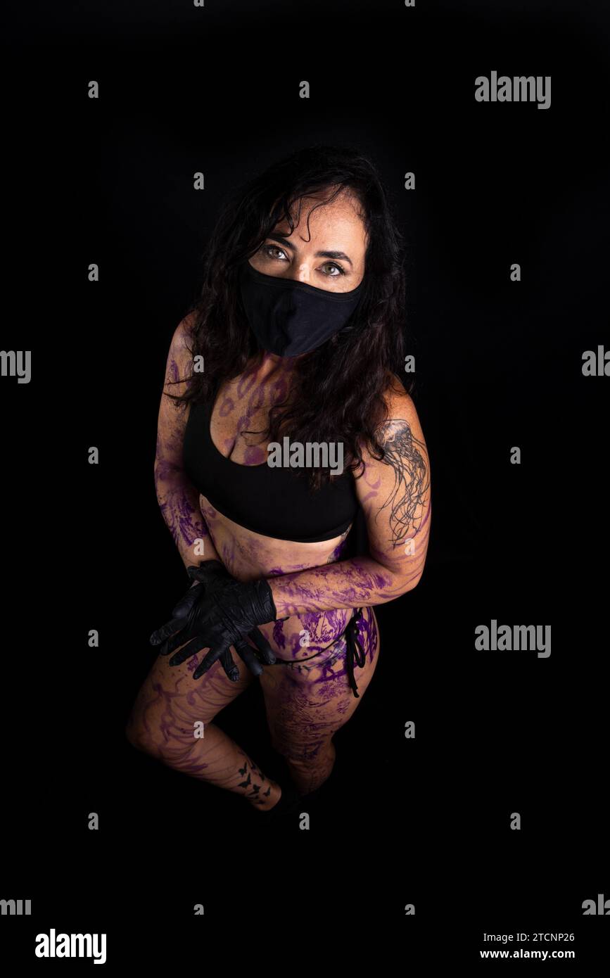 Femme artiste de tatouage debout avec le corps peint sur fond noir Banque D'Images