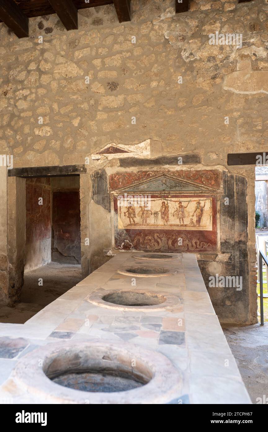 Pompéi, Italie : 2023 novembre 16 : ancien comptoir de bar de l'ancienne Pompéi (site du patrimoine mondial de l'UNESCO). Pavés de la via del Foro en novembre Banque D'Images