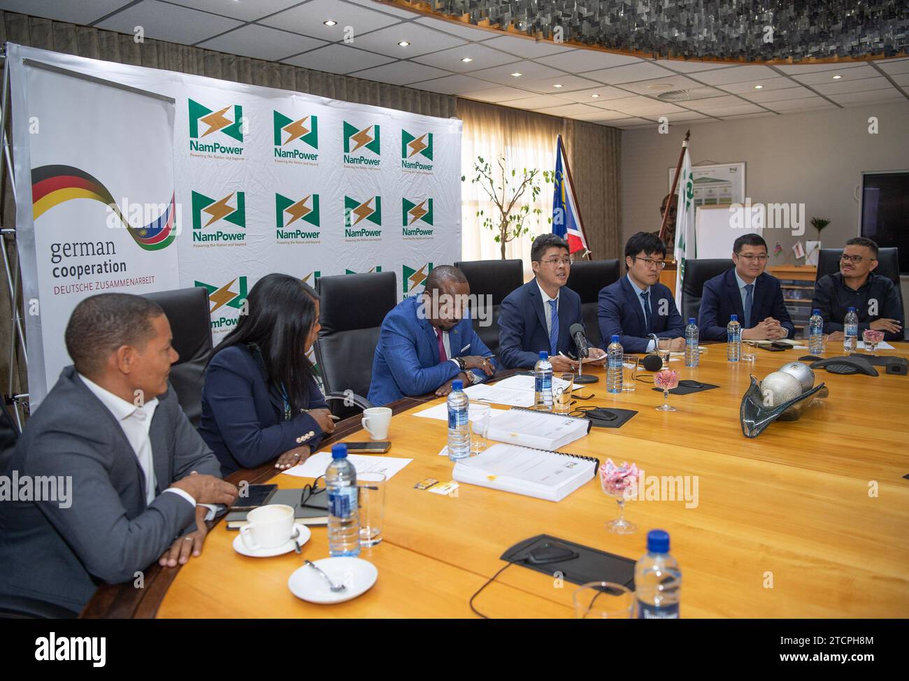 Windhoek, Namibie. 13 décembre 2023. Jin BEI (C), représentant du Shandong Electrical Engineering & Equipment Group, intervient lors de la cérémonie de signature du système de stockage de l'énergie par batterie (BESS) à Windhoek, en Namibie, le 13 décembre 2023. La compagnie d'électricité namibienne, NamPower, a signé mercredi un accord avec deux entreprises chinoises pour le développement du premier BESS à l'échelle de 54 MW/54 MWH du pays. POUR ALLER AVEC «Premier système de stockage d'énergie de batterie à l'échelle utilitaire à être développé en Namibie» crédit : Chen Cheng/Xinhua/Alamy Live News Banque D'Images