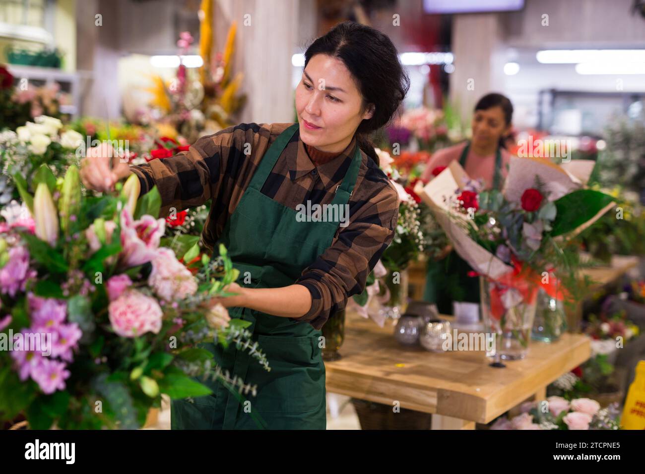 Le vendeur de fleurs asiatique prépare un bouquet de luxe à la boutique de fleurs Banque D'Images