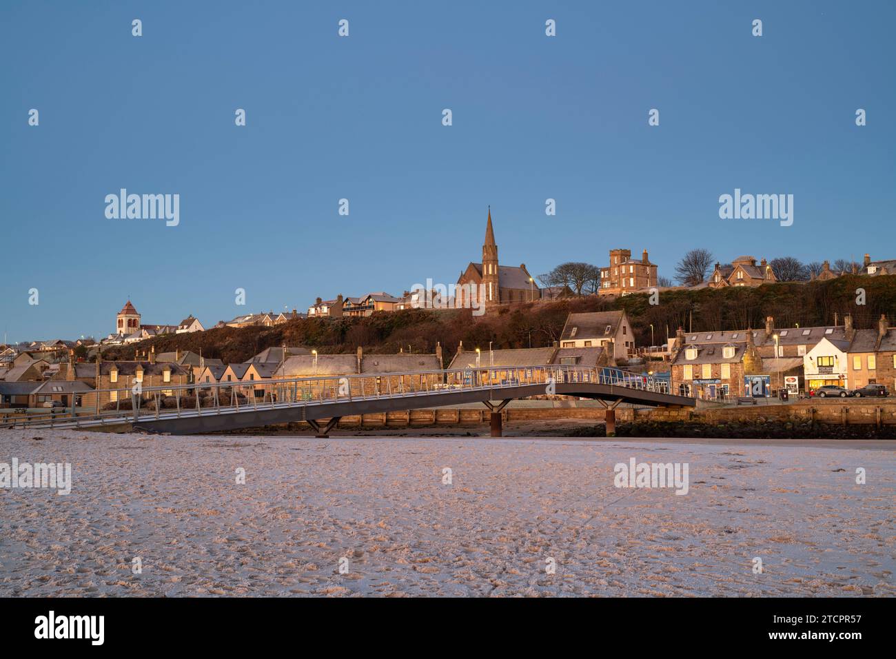 Lueur d'aube d'hiver givrée sur la passerelle de Lossiemouth et maisons d'East Beach. Lossiemouth, Morayshire, Écosse Banque D'Images