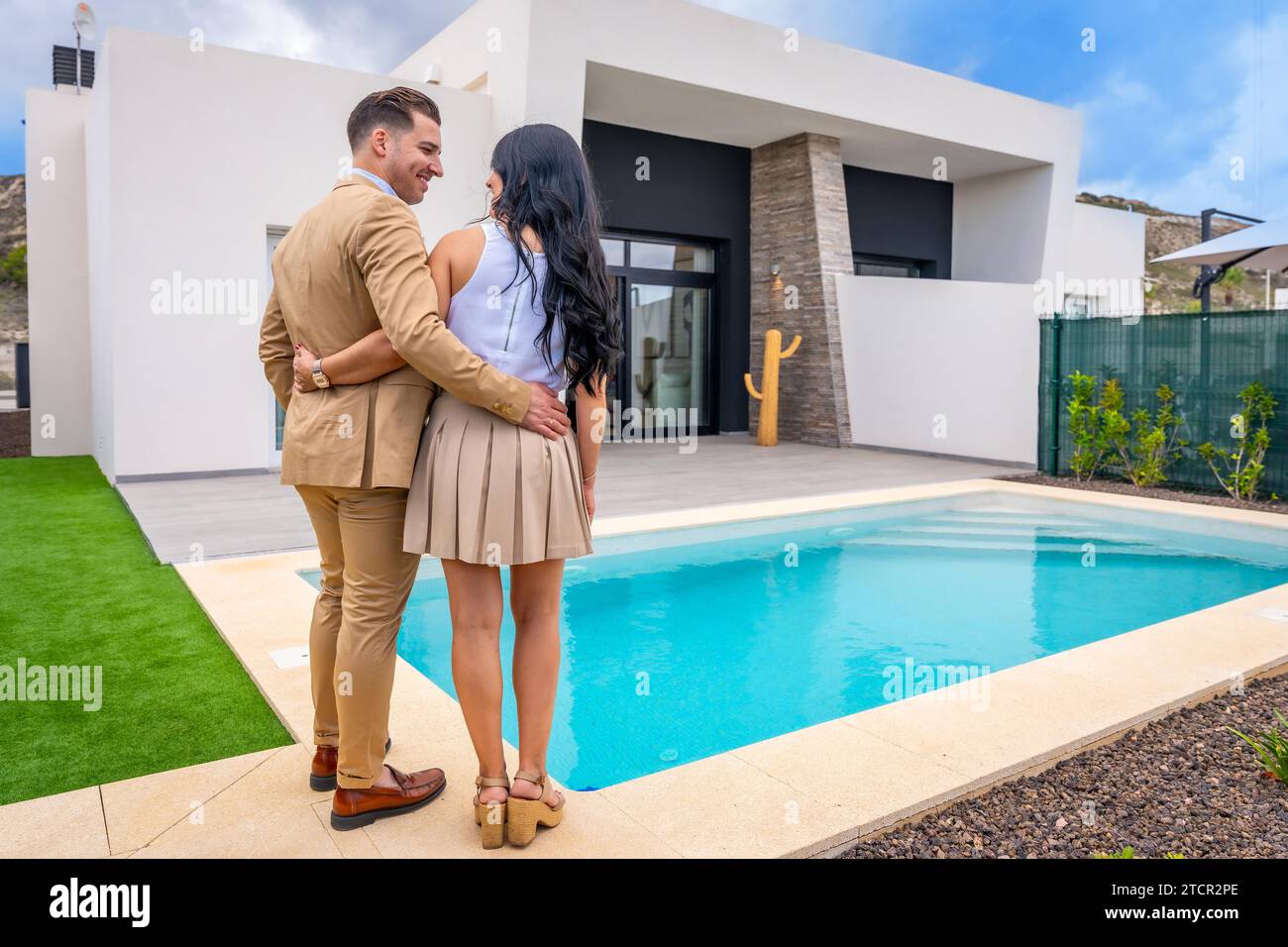 Vue arrière d'un fier couple contemplant leur maison nouvellement achetée Banque D'Images