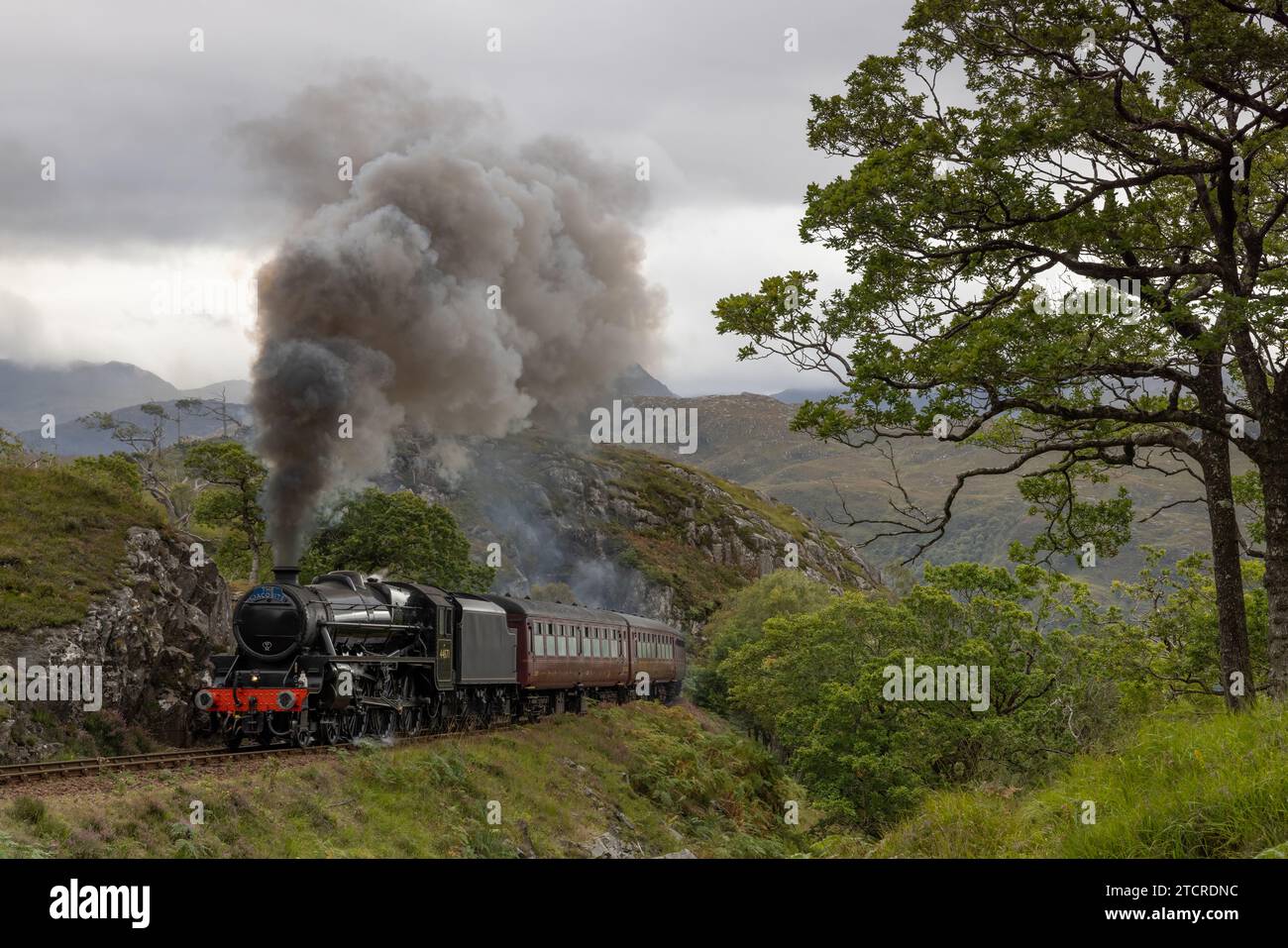 Le train à vapeur s'approche de la caméra avec de la vapeur bouillonnante. Conduites principales avec vapeur et fumée. Train Fanous utilisé dans Harry Potter comme Poudlard Express. Banque D'Images