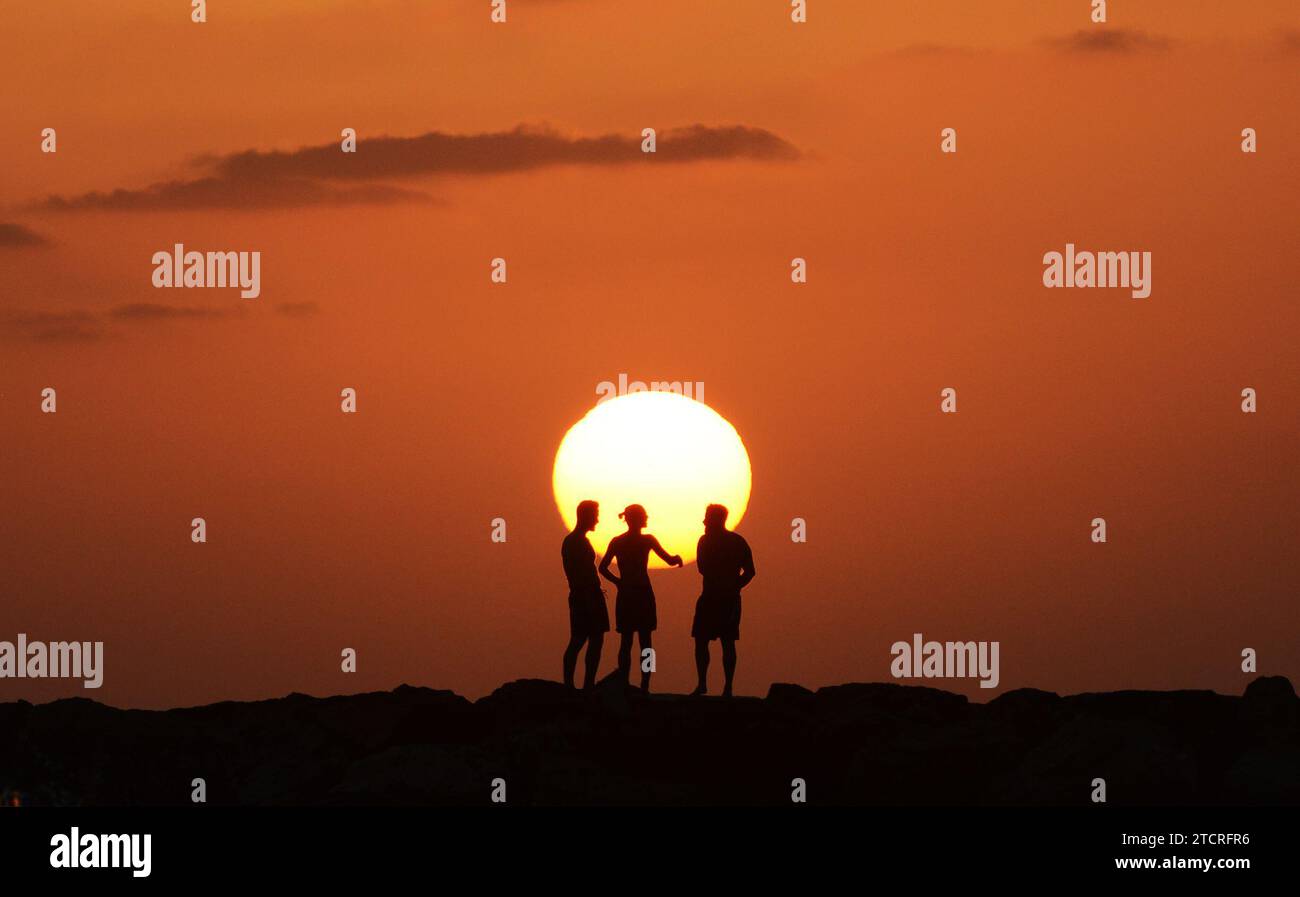 Les amis apprécient le magnifique coucher de soleil sur la plage de tel-Aviv, Israël. Banque D'Images