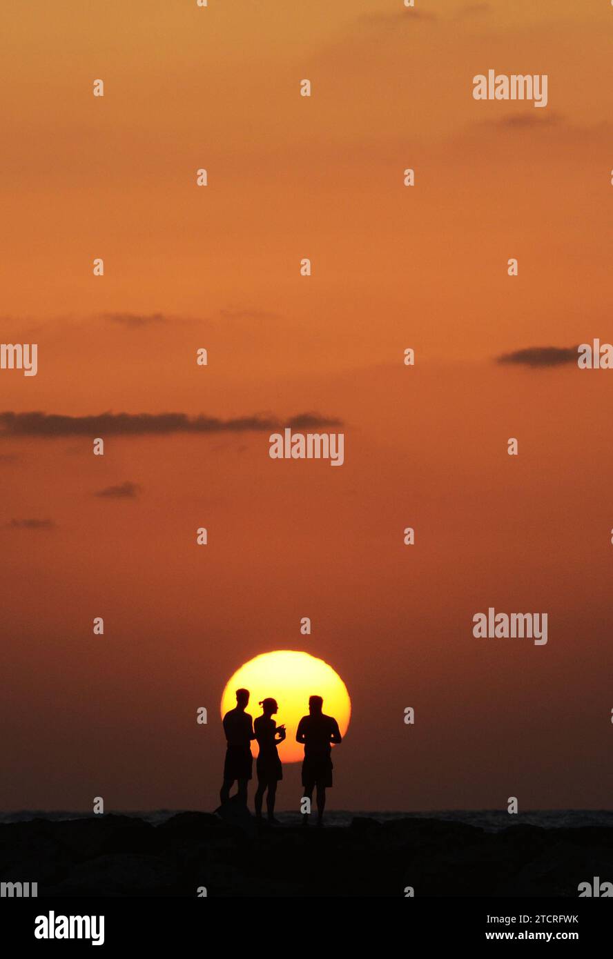Les amis apprécient le magnifique coucher de soleil sur la plage de tel-Aviv, Israël. Banque D'Images