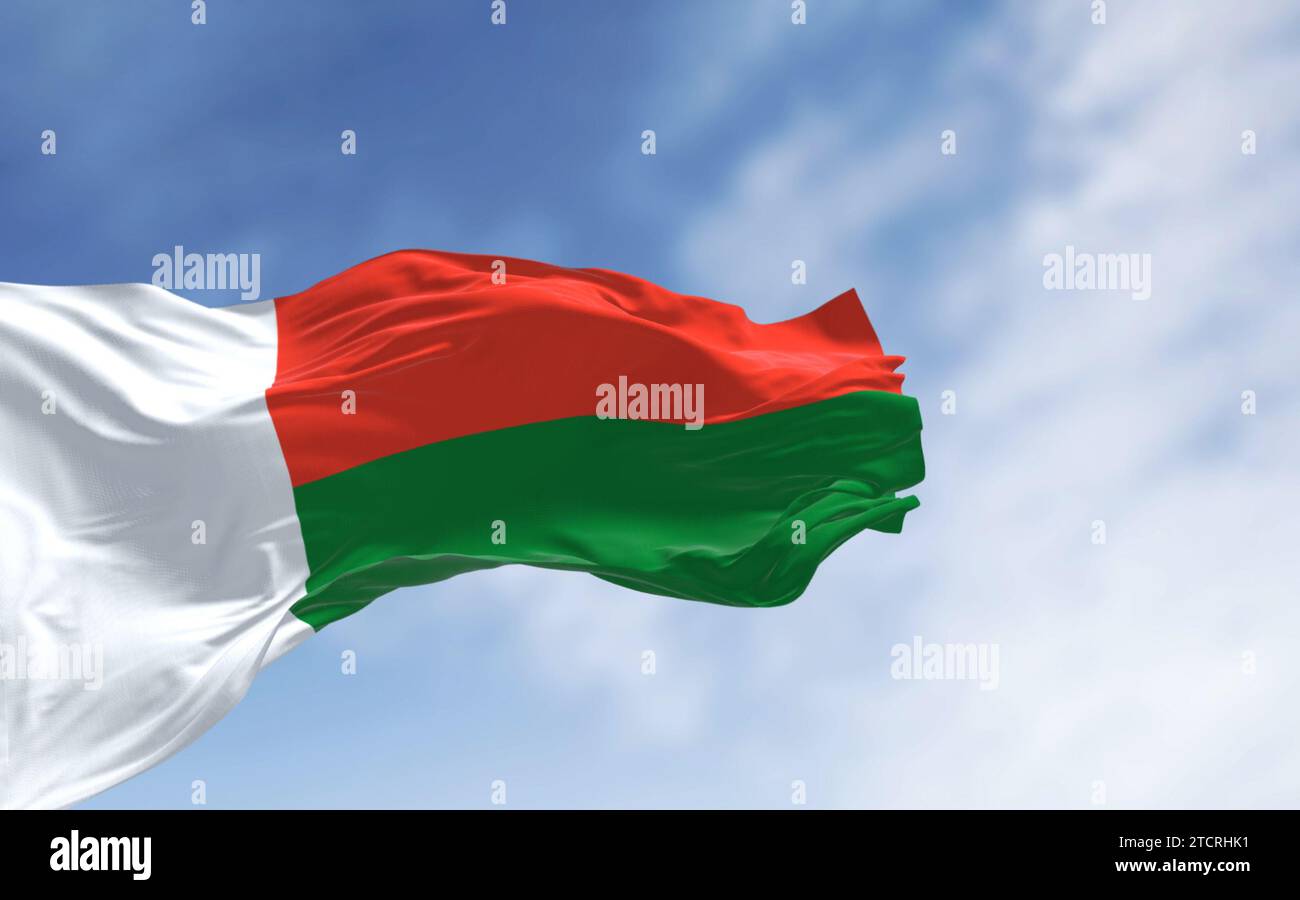 Drapeau national de Madagascar agitant dans le vent par temps clair. Deux bandes horizontales rouge et verte, avec une bande verticale blanche à gauche. 3d illus Banque D'Images