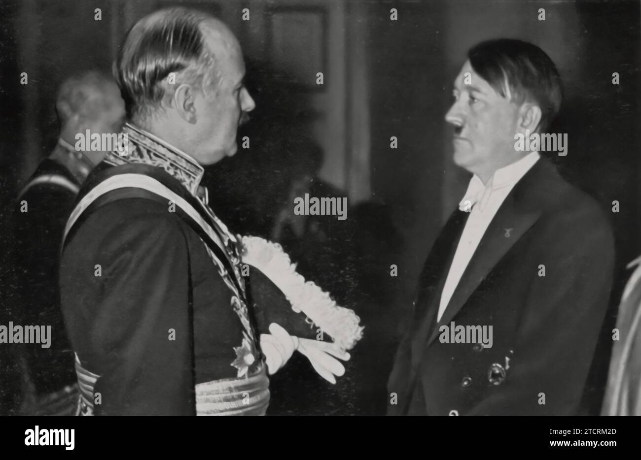 Adolf Hitler, chancelier du Reich, est montré engagé dans une conversation avec l'ambassadeur de France, André François-Poncet, lors d'une réception du nouvel an. Cette interaction représente un moment de diplomatie de haut niveau entre l’Allemagne nazie et la France. Banque D'Images