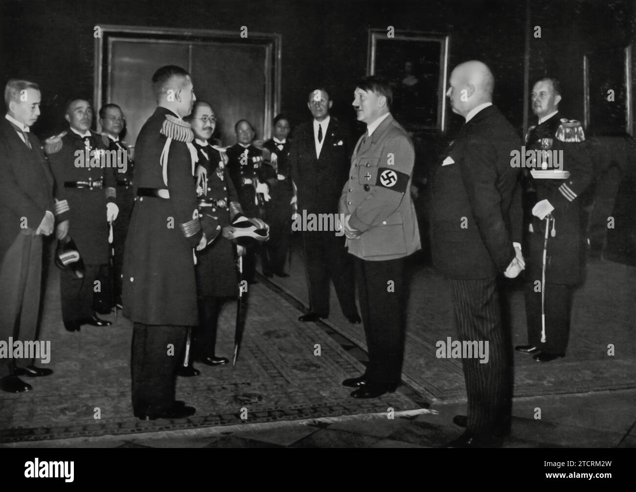 En 1934, Adolf Hitler reçoit une délégation de la marine japonaise, signifiant les liens croissants entre l'Allemagne nazie et le Japon pendant cette période. Cette réunion souligne le rayonnement international du régime nazi et ses efforts pour établir et renforcer des relations avec d’autres puissances militaires. De telles interactions ont été cruciales dans la période précédant la Seconde Guerre mondiale, alors que les pays ont établi leurs alliances géopolitiques et militaires. Banque D'Images