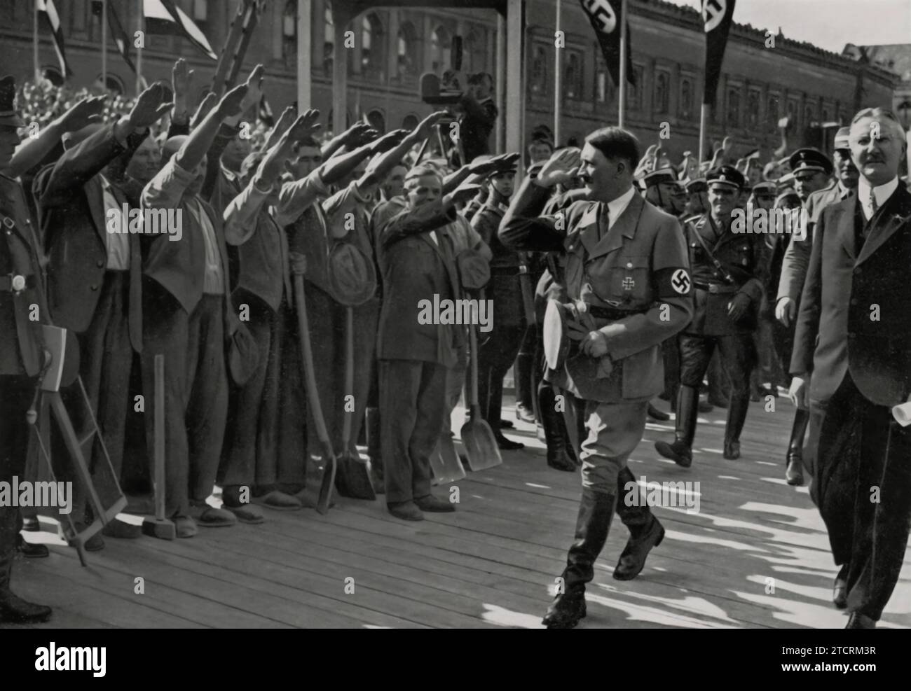 Le 5 mai 1934, Adolf Hitler assiste à la pose de la première pierre du nouveau bâtiment de la Reichsbank, un événement important dans le développement économique de l'Allemagne nazie. Cette cérémonie symbolise l'accent mis par le régime sur le contrôle financier et la grandeur architecturale, reflétant ses ambitions plus larges de remodeler le paysage économique de l'Allemagne. Banque D'Images