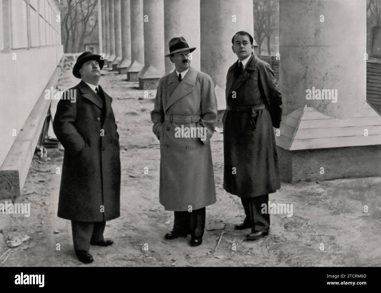 Adolf Hitler, aux côtés du professeur Gall et de l'architecte Albert Speer, inspecte l'état d'avancement de la construction de la Maison d'Art Allemand à Munich. Cette visite met en lumière la collaboration entre Hitler et d’éminents architectes dans la réalisation de sa vision de l’architecture nazie. La Maison de l'art allemand, un projet clé pour le régime, a été conçue pour incarner les idéaux nazis dans l'art et l'architecture. Speer, connu pour son étroite association avec Hitler, a joué un rôle crucial dans la concrétisation de ces visions architecturales, la Maison de l'Art allemand étant un exemple parfait de leurs efforts communs. Banque D'Images
